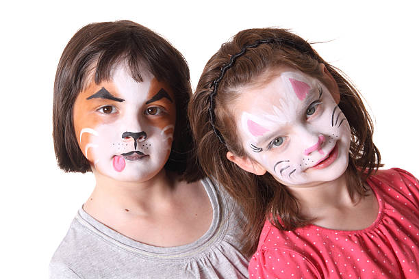 Children with Painted Faces Two sisters with their faces painted like animals on a white background cat face paint stock pictures, royalty-free photos & images