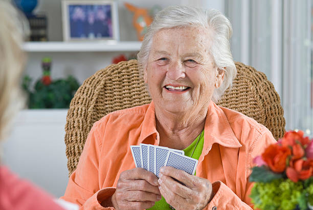 istock Senior Woman smiling while playing a card game 182750456