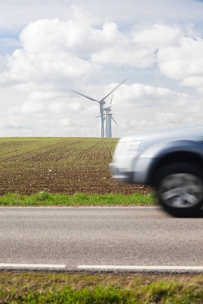 istock Car passing wind turbines on hill top. Motion blur. 182750477