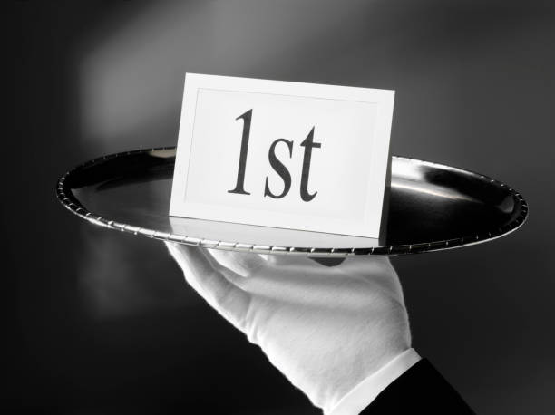 1st, First Class Service on a Serving Tray First class service. Waiter holding a first card on a silver tray. Click on the link below to see more of my business images. silver platter stock pictures, royalty-free photos & images