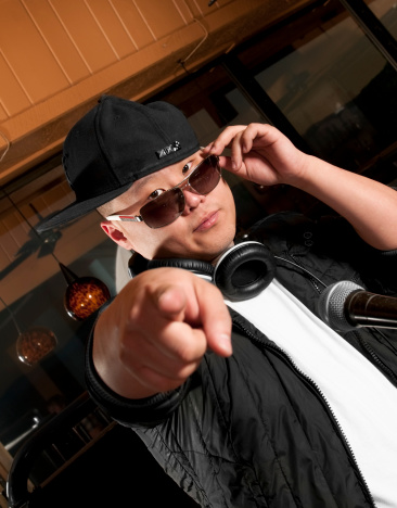 DJ spinning in a club and pointing.