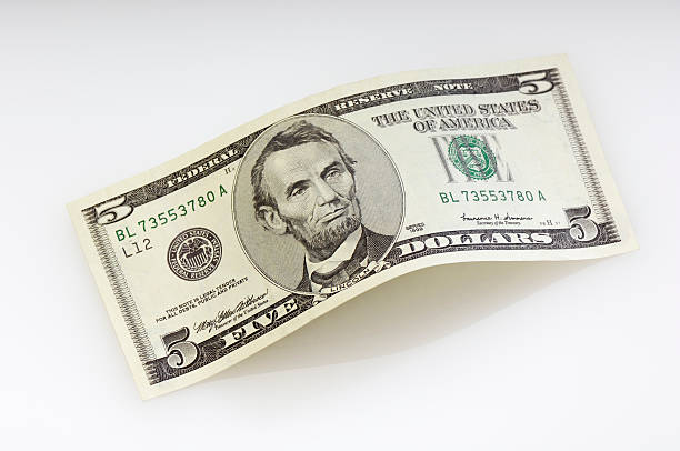 Bent five dollar bill Bent five dollar bill. (XXL-File) five dollar bill stock pictures, royalty-free photos & images