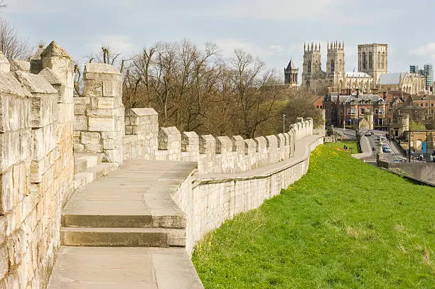 "A view along the historic York, England city wall with the famous York Minster in the distance."
