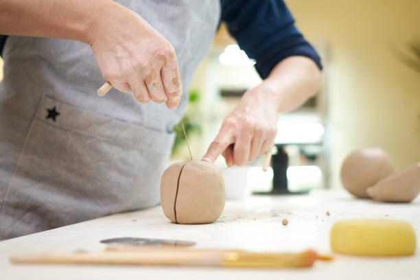 istock female potter cutting clay with thread at pottery studio 1827520056