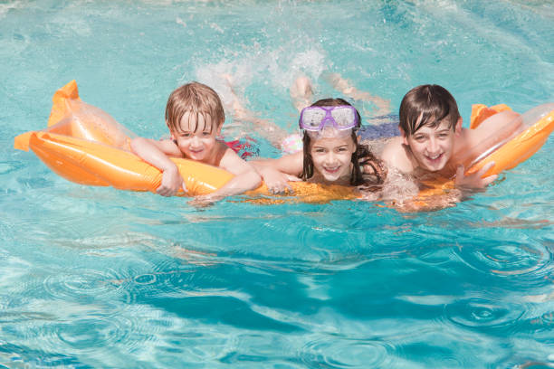 istock Three happy children swimming in a pool 182752152
