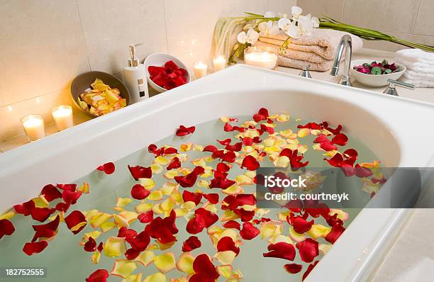 Tratamiento De Spa Bañera Con Pétalos De Rosa Flotante Foto de stock y más banco de imágenes de Bañera