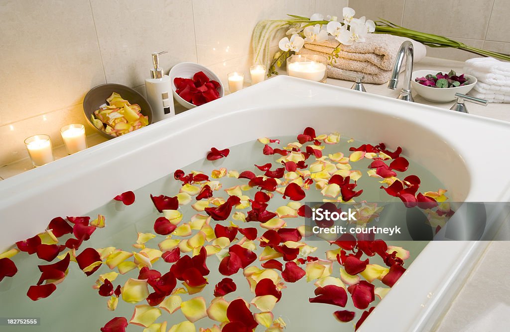 スパのトリートメントは、バラの花びらを浮かべたバスタブ - 風呂のロイヤリティフリーストックフォト