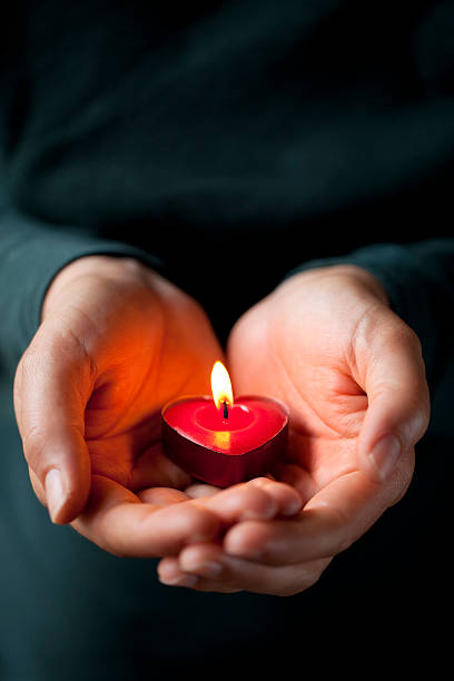 istock Heart-shaped candle in her hands 182752869