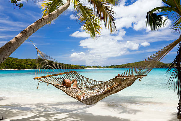 beautiful young woman getting some sun in hammock at the Caribbean beach