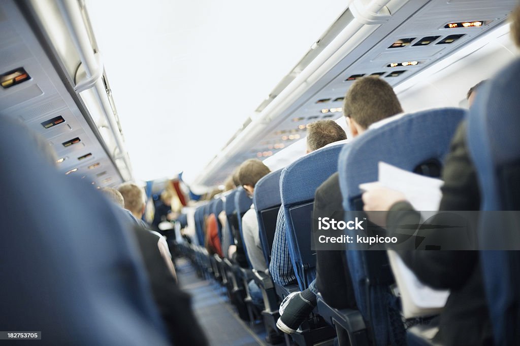 Airplane aisle with group of passengers Airplane aisle with rear view of passengers Adult Stock Photo