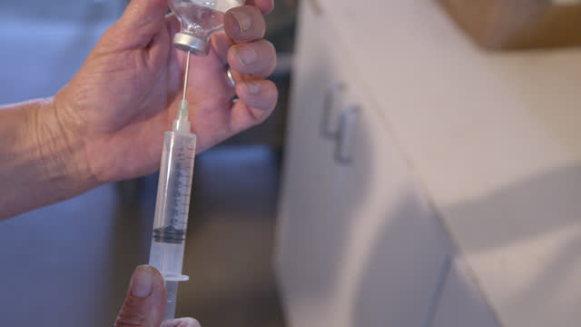 Close-Up Shot of a Veterinarian Drawing Medication with Syringe