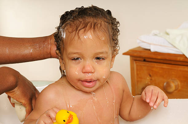 Baby Soaking Wet During Bathtime A biracial baby soaking wet during a bath.http://images.eu.viewbook.com/e4dc2466aaa35ecbcdd14f75226f8999.jpg  black woman washing hair stock pictures, royalty-free photos & images