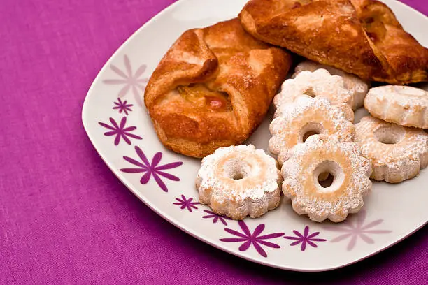 Delicious dish for a sweet breakfast: bundles of apples and some typical italians biscuits.
