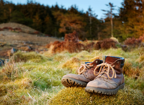 A royalty free stock photo of a pair of walking boots in a country setting.