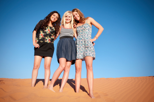 A Diverse group of three beautiful young women in the Sand Dunes of Utah.