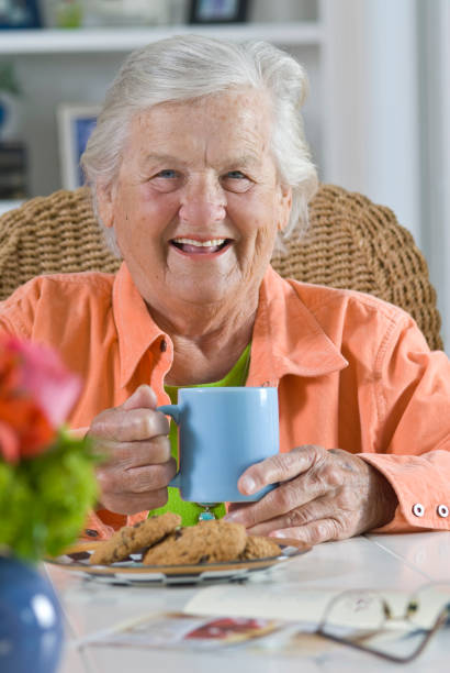 istock Elderly Lady with a Mug and Cookies Smiling at the Camera 182755257