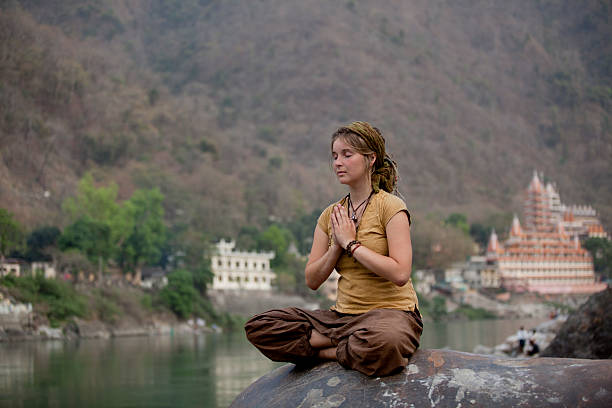 若い女性がガンジス川で瞑想するリシケーシュは、インド - yoga outdoors hippie people ストックフォトと画像