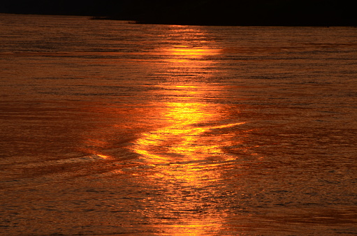Tropical amazing dramatic golden sky on sunset over scenic river lake seascape ocean. Silhouette tranquil season wilderness serene landscape. Tranquil lake countryside sunrise seaside reflection