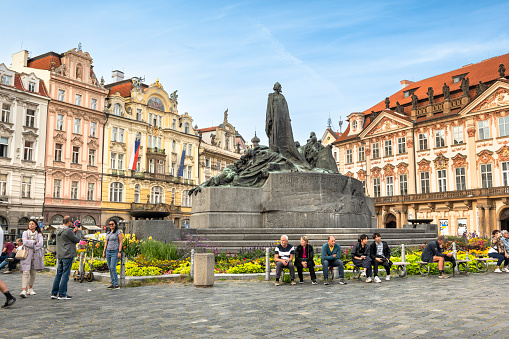 Prague, Czechia - September 12, 2022:  People walk along the medieval cobblestone streets and old historic buildings of Old Town Square by the Jan Hus monument sculpture statue in Prague Czech Republic