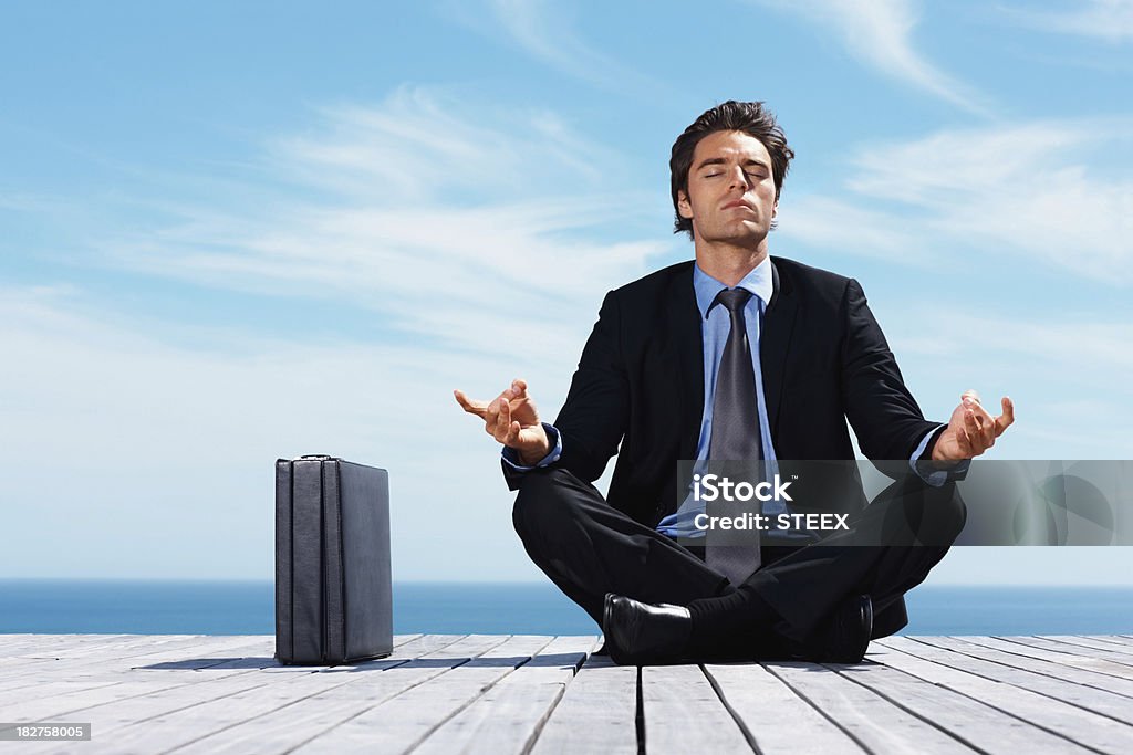 Yoga-jeune homme Assis en tailleur position assise sur la jetée - Photo de Hommes libre de droits
