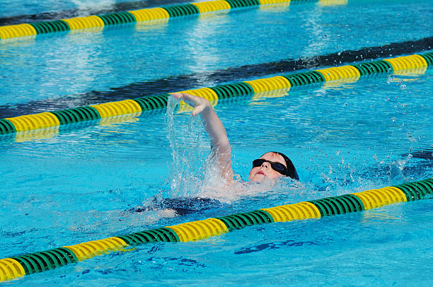 istock Young Boy Male Athlete Backstroke Swimming Racing in Pool 182758251