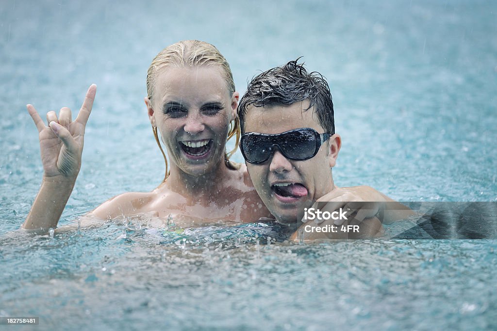 Monsoon Rain Fun (XXXL) Beautiful couple standing in the basin of a waterfall in the middle of heavy Monsoon Rain. Perfect candid smile. (XXXL) Blue Stock Photo