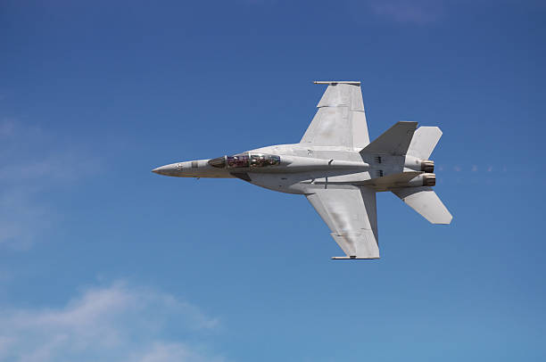 istock Gray F-18 fighter jet flies with a blue sky behind it 182758855