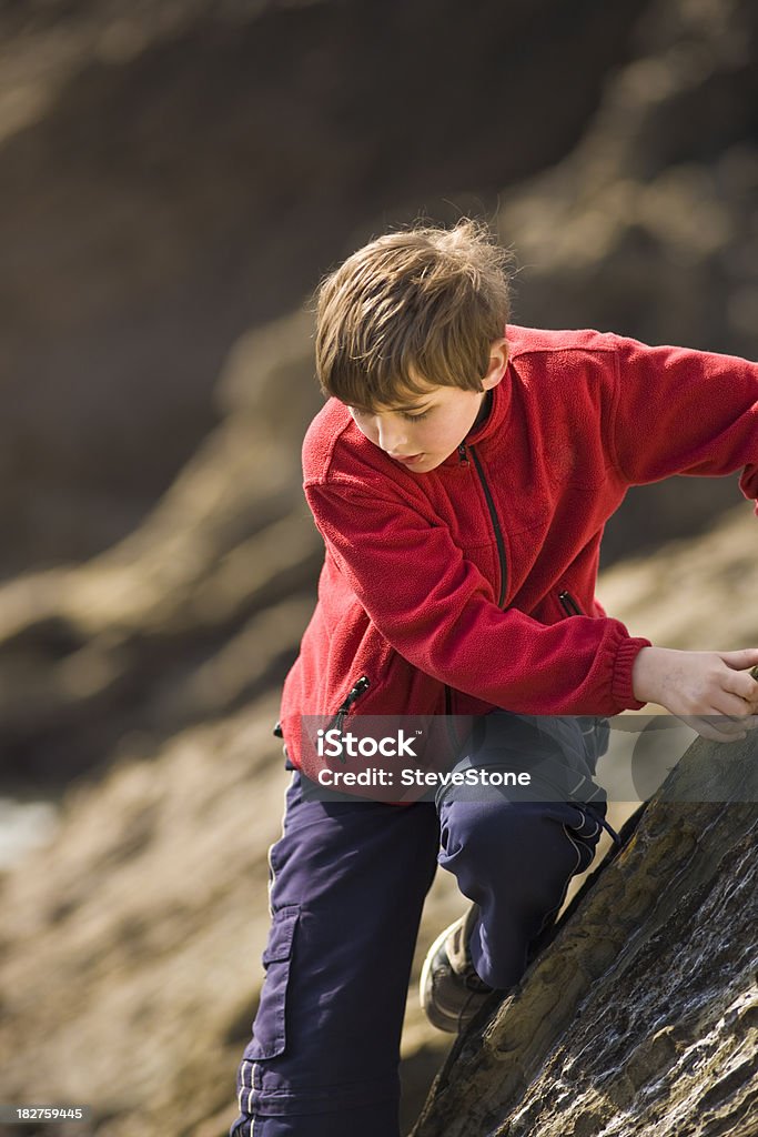 Garoto escalando cuidadosamente de rocks - Foto de stock de Criança royalty-free