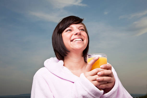 istock young woman drinking orange juice 182759475