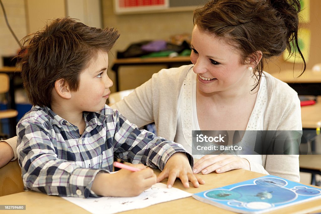 Professeur jeune femme travaillant avec un petit garçon - Photo de Enseignant libre de droits