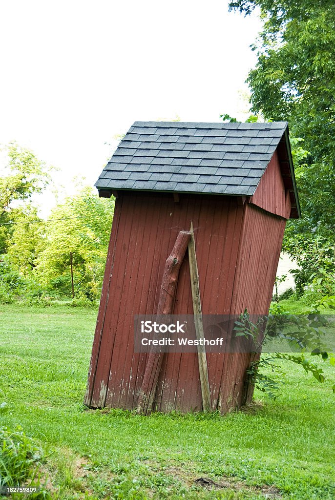Leaning Outhouse An old outhouse struggles to stay standing. Bathroom Stock Photo