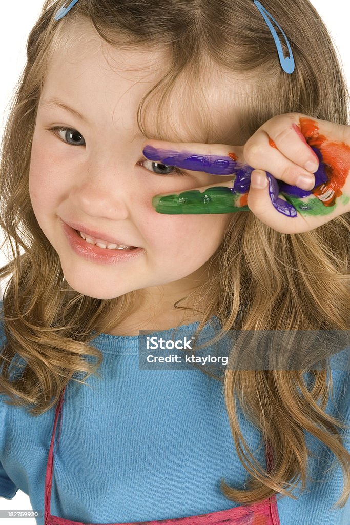 Peeking through painted hand Beautiful little girl looks through her painted hand Close-up Stock Photo