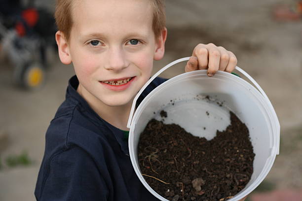 boy holding bucket full of worms boy holding bucket full of worms lethbridge alberta stock pictures, royalty-free photos & images