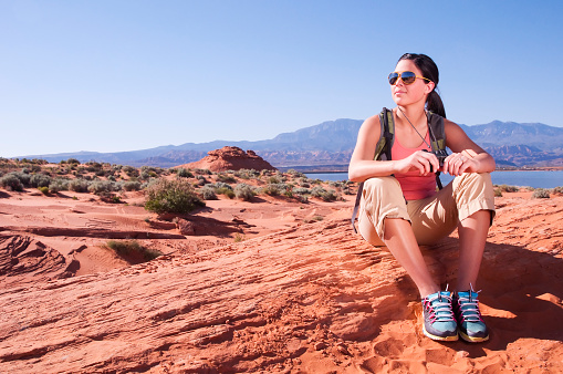 A young woman takes a rest from hiking in the desert. Shot in southern Utah.