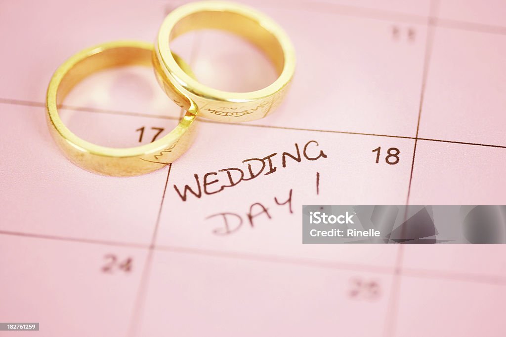 Wedding Day A pair of gold rings on a pink calendar with 'wedding day' marked.  Shallow depth of field. Wedding Stock Photo
