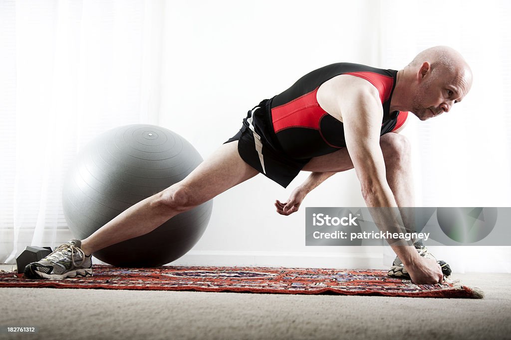 Man Stretching A middle aged man stretches before a workout. Fitness Ball Stock Photo