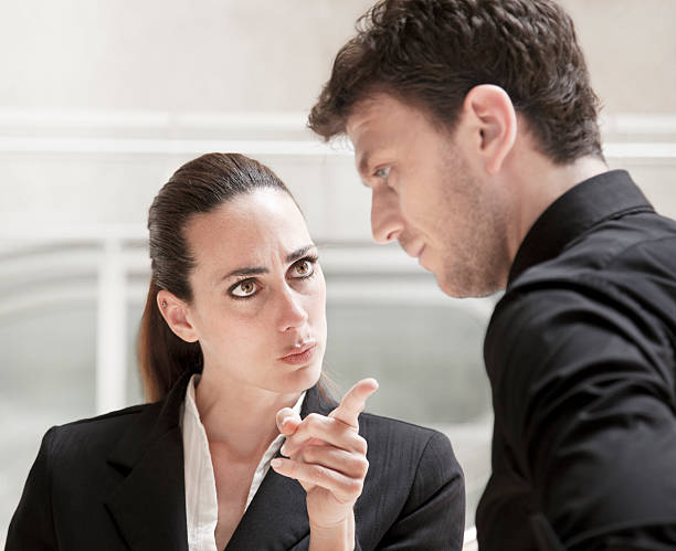 Office conflict business woman bully scolding and harrasing a worker stock photo