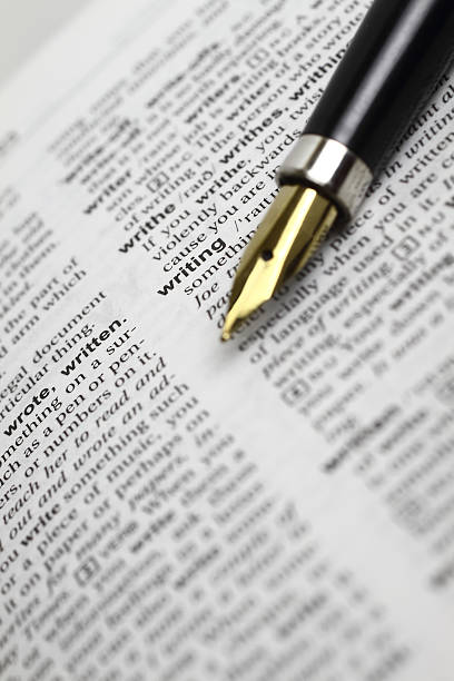 An open dictionary and a fountain pen stock photo