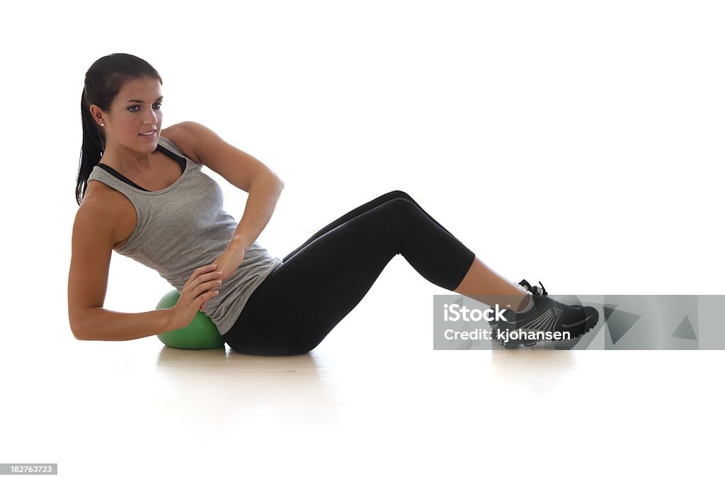 Physically Fit Latina Doing Crunches A personal trainer demonstrates ab work on an exercise ball. Isolated on white. 20-24 Years Stock Photo