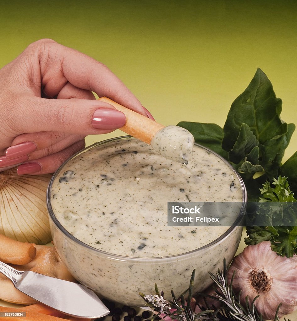 Creamy Basil Dip Female pretty hand dipping a carrot stick in a basil based dressing. Appetizer Stock Photo