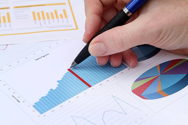 istock A hand writing in pen and a graph of financial data 182764131