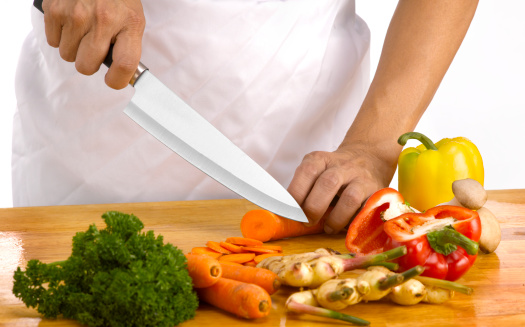 A Chef chopping food ingredients on wooden board