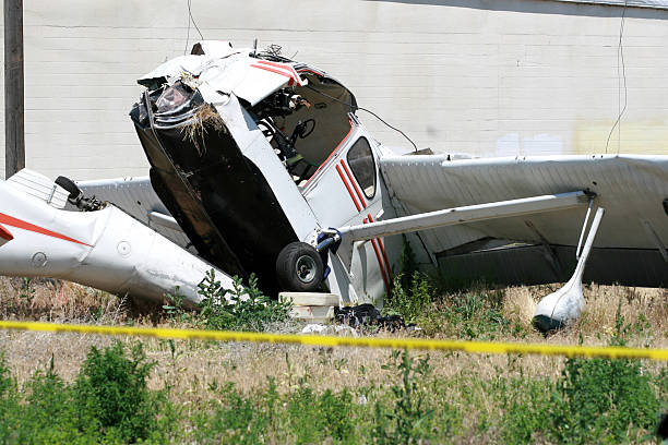 Airplane Crash A small airplane crashed in a field near a big warehouse building. airplane crash photos stock pictures, royalty-free photos & images