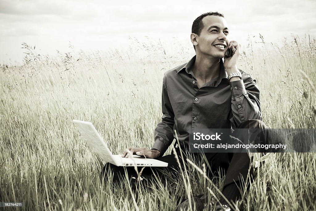 Latino-americano maschio con computer portatile e telefono - Foto stock royalty-free di Abbigliamento