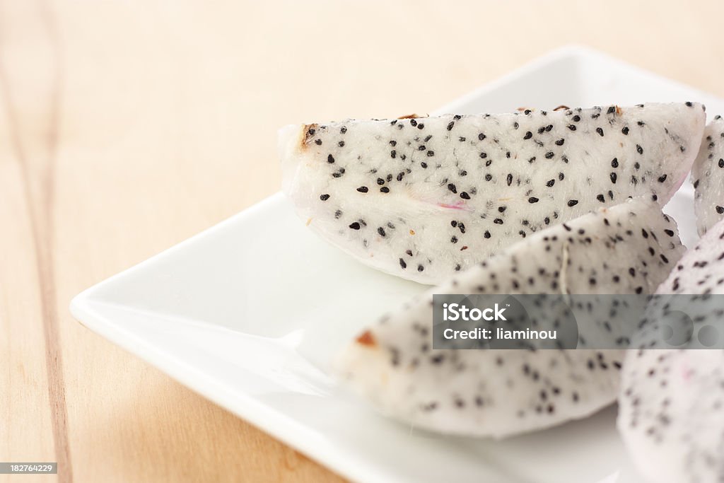 Dragon fruit slices on a plate peeled dragon fruit slices on a white plate on wooden desk Beauty Stock Photo