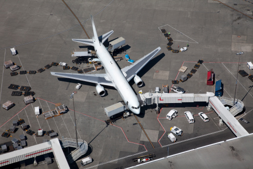 A large passenger airplane being readied for departure.  Aerial view.