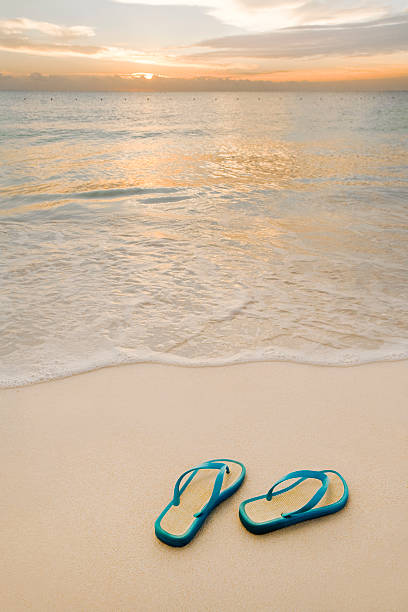 istock Sandals On The Beach By A Smooth Sunrise 182764896