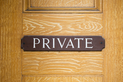 Private sign on wooden door.