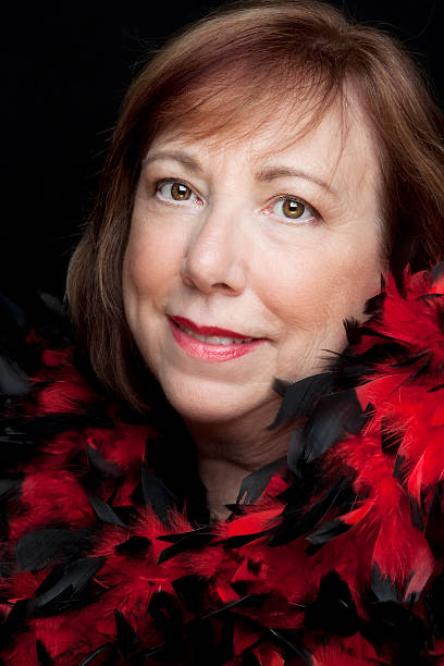 Beautiful senior woman wearing red boa black Beautiful senior woman wearing red and black boa on black background. You might also be interested in this: actress headshot stock pictures, royalty-free photos & images