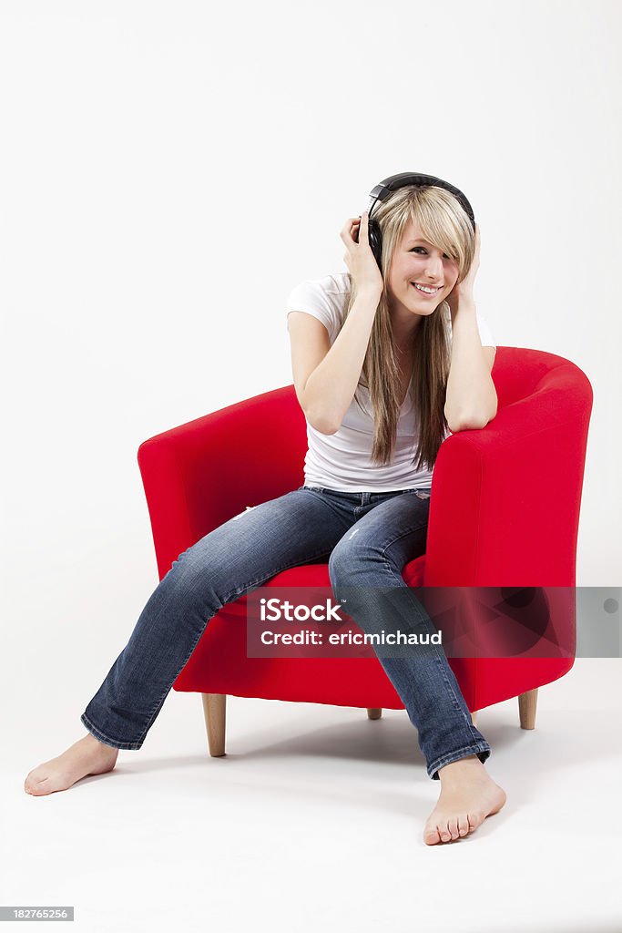 Bella ragazza seduta in cuffie Ascolta musica in poltrona - Foto stock royalty-free di 14-15 anni